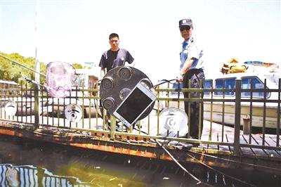 ↑周翔军正在使用自制的“神器”帮助游客打捞物品供图/杭州市公安局西湖风景名胜区分局