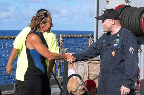 阿佩尔（左）和解救她的美国海军人员握手。图片来源：美国海军