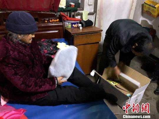 图为：郭柯一行人把上海高中生们寄的礼物送给山西骈焕英老人(左)。 受访者供图