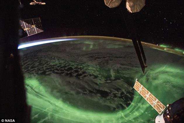 照片中，绿莹莹的极光在地球上空旋舞，与此同时，南半球正迎来晨曦微露。这张照片原发于美国宇航员里奇·阿诺德的Instagram，配文为“日出闯进了一场南半球的极光盛宴。”