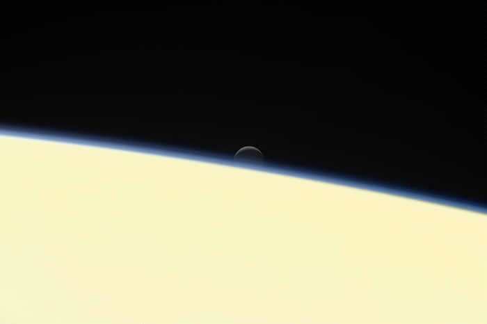 美国航太总署的卡西尼号太空船在2017年9月15日冲入土星自毁，这张影像是卡西尼号所拍摄的告别作之一，可以看到冰冷的土卫二沉没在土星后方。 PHOTOGRAPH