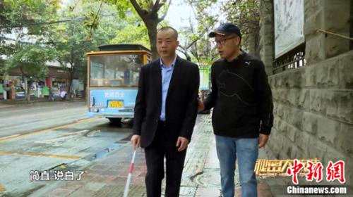 刘京川作为志愿者帮助全盲人士学习使用盲杖