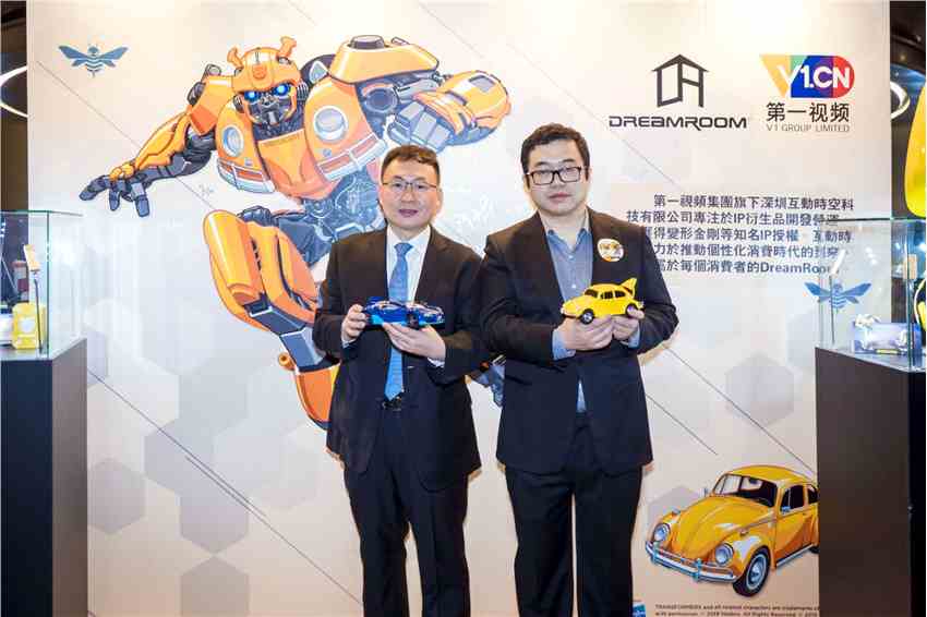 第一视频CFO刘怀宇(左)和互动时空董事长颜戎(右)展示变形金刚系列Dreamroom衍生品