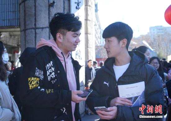 2月16日，北京电影学院艺考拉开序幕。图为两名考生考试结束后在校门外交谈。中新社记者 张兴龙 摄
