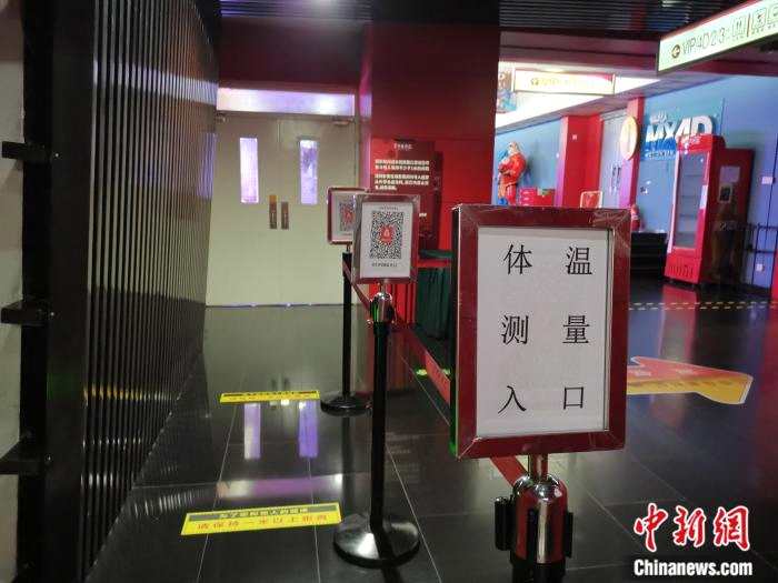 7月23日晚，首都电影院西单店，入口通道已设置“体温测量入口”及北京健康宝指示牌。任思雨 摄
