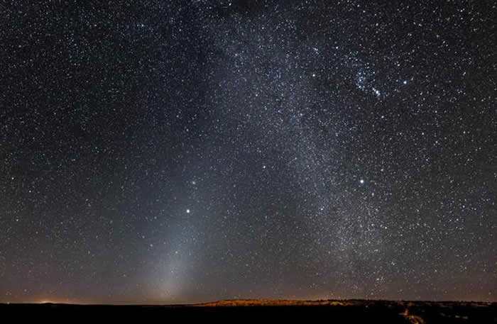该图像呈现的是一种被称为“黄道光”的现象，在图中左下方，一个发光斑块向木星方向延伸至右上方，木星中图中中心左侧的明亮天体，黄道光是由太阳系内部微小尘埃(彗星和小