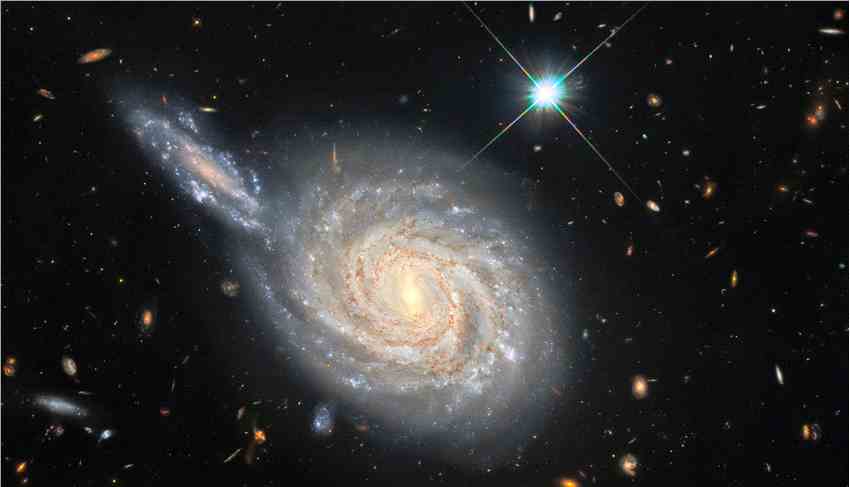 哈勃太空望远镜捕捉到的双鱼座螺旋星系NGC 105 似正在与邻近星系发生碰撞但实际不是