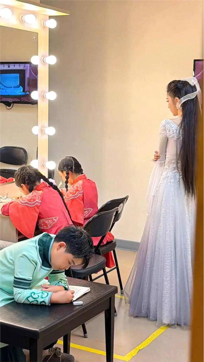 佟丽娅穿着仙女裙 在演出后台给孩子报听写
