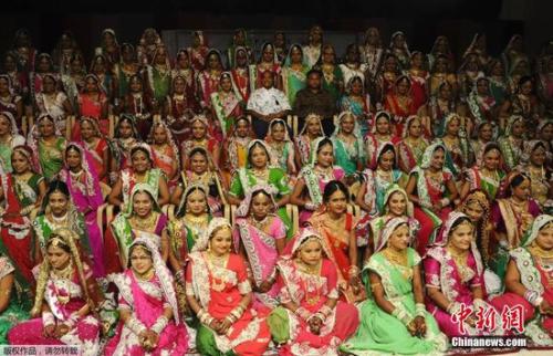 12月9日消息，近日在印度西部古吉拉特邦举行了一场盛大的151对新人的结婚典礼。婚礼上，151名新娘身着红色的传统服饰，佩戴华丽首饰，十分明艳动人。据悉，这场集体婚礼由一位珠宝商人提供赞助，数年前，这名珠宝商人就开始为没有父母的贫家女孩筹办集体婚礼，因为按照印度的传统，准新娘要出嫁时，娘家会为其准备丰厚的嫁妆，而对于贫困的女孩，这点则变得有些困难。这场集体婚礼的宴席将持续3天，预计接待超过10万名宾客，婚礼花费加上新娘的黄金首饰嫁妆共达到75万美元。
