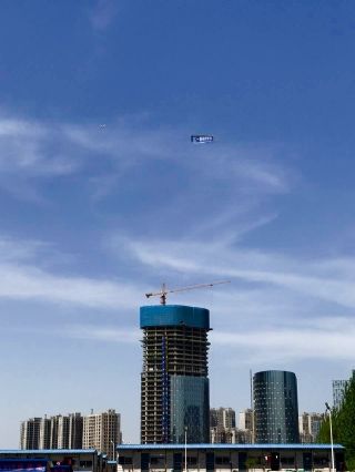 “空中海报”特技飞机在城市主城区上空飞行。