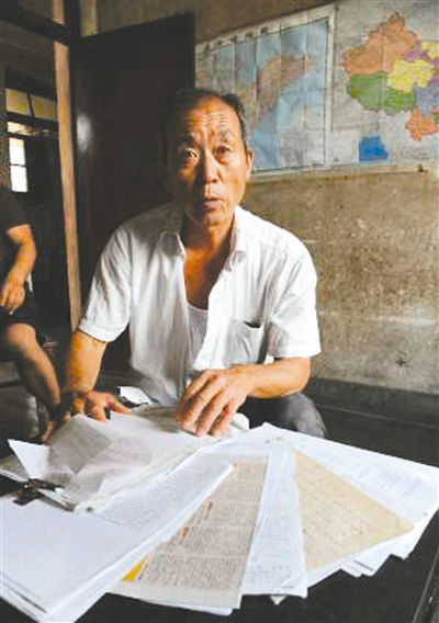 原文配图：李东虎搜集了很多杨屯中学埋有川军遗骸的资料。