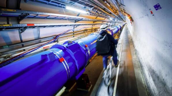 一名男子骑着自行车沿着欧洲核子研究中心粒子加速器的一部分.jpg