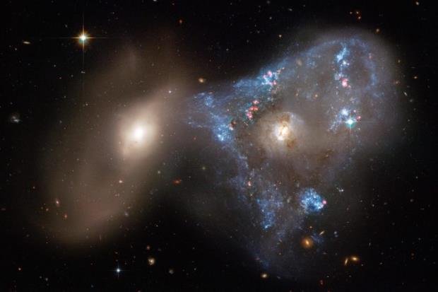 美国宇航局哈勃太空望远镜拍摄的一张新照片捕捉到了两个星系之间壮观的正面碰撞，助长了不寻常的三角形恒星诞生狂潮.jpg