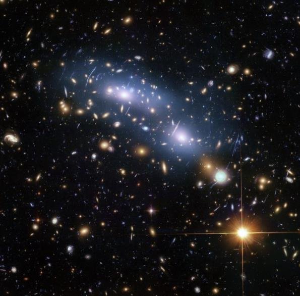 这张来自 NASA ESA 哈勃太空望远镜的图像显示了星系团 MACS J0416。这是哈勃前沿领域计划正在研究的六个星系团之一，它们共同产生了有史以来最深的引力透镜图像。科学家们使用星团内光（蓝色可见）来研究星团内暗物质的分布.jpg
